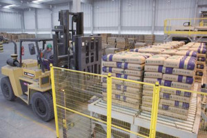 Paletizadora na Cia. de Cimento Itambé entrega o volume correto de sacos de cimento, para que a empilhadeira possa carregar os paletes nos caminhões.  Crédito: Cia. de Cimento Itambé